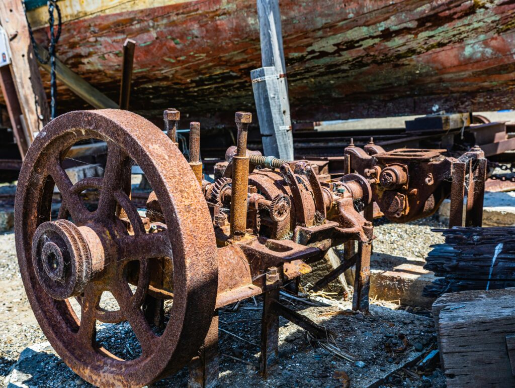 Close-up of corroded, abandoned ship engine with rust, evoking a vintage industrial mood.